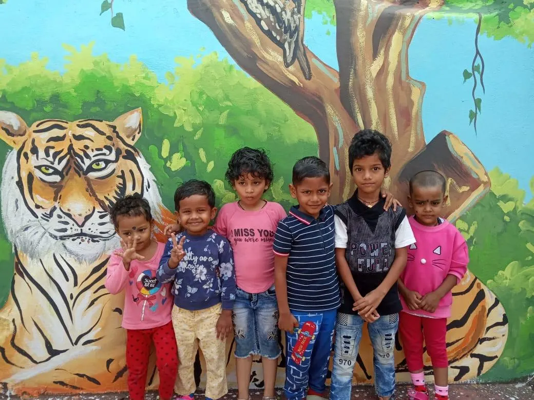 Friends beside a colourful tiger mural