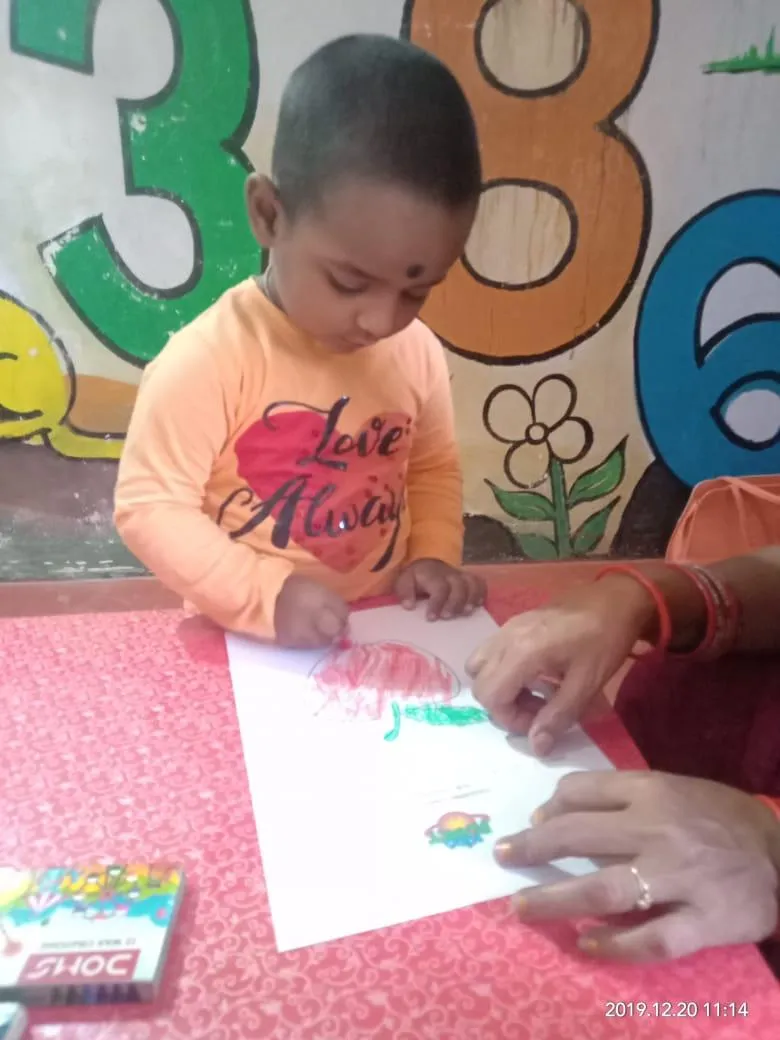A child receiving help with colouring