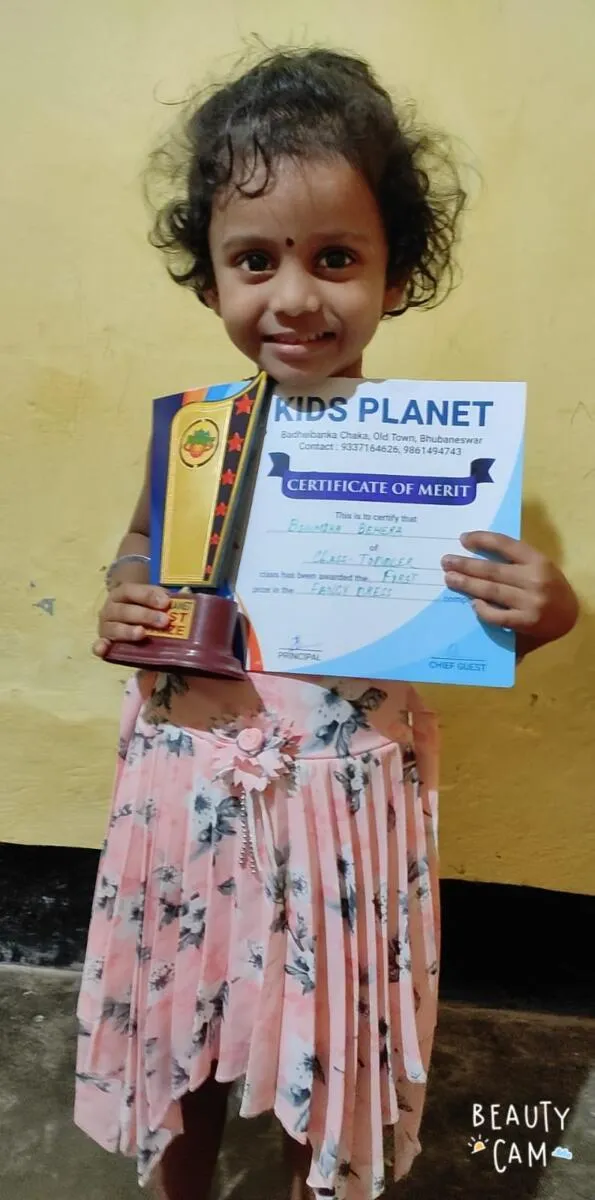 A child holding a certificate and trophy