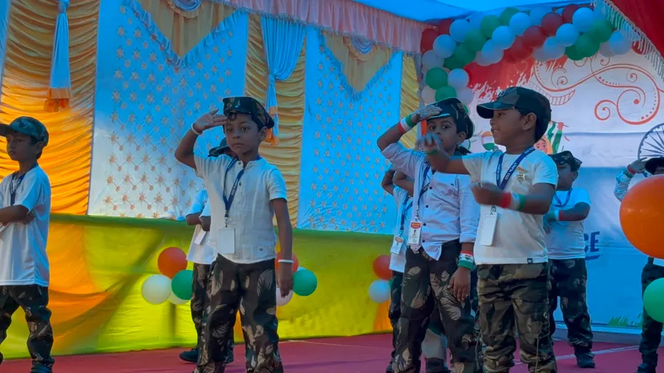 Children saluting during a school stage performance at Kids Planet